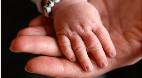 Kinderhand auf Erwachsenenhand - Leihmutterschaft in der Ukraine